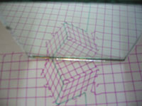 Fotografia en la que un espejo secciona oblicuamente el cubo inicial,cuyo reflejo compone la primera combinación.